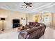 Inviting living room with a large leather sofa, tile flooring, and elegant tray ceiling at 4961 Sabal Lake Cir, Sarasota, FL 34238