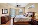 Spacious main bedroom with hardwood floors, decorative headboard, and views of pool and waterway at 4961 Sabal Lake Cir, Sarasota, FL 34238