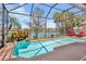 Sparkling screened-in pool with lake view, surrounded by lush landscaping, creating a serene outdoor oasis at 4961 Sabal Lake Cir, Sarasota, FL 34238