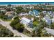 Aerial view of a coastal home boasting a pool, lush landscaping, and proximity to the beach and ocean at 497 Island Cir, Sarasota, FL 34242