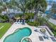Aerial view of a pool, spa, firepit, and lounge chairs in a landscaped yard at 497 Island Cir, Sarasota, FL 34242