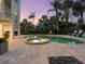 Expansive backyard featuring a heated pool and spa, lush landscaping, and a spiral staircase leading to an upper-level balcony at 497 Island Cir, Sarasota, FL 34242
