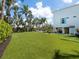 The backyard features lush lawn, tropical landscaping, and outdoor seating area at 497 Island Cir, Sarasota, FL 34242