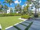 The backyard showcases lush grass, mature landscaping, stepping stones, and a seating area at 497 Island Cir, Sarasota, FL 34242