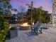 Picturesque backyard retreat featuring a fire pit with Adirondack chairs and elegant landscaping surrounded by palm trees at 497 Island Cir, Sarasota, FL 34242