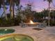Charming backyard with a cozy firepit, comfortable Adirondack chairs, lush landscaping, pool, and a spa at 497 Island Cir, Sarasota, FL 34242