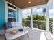 Inviting outdoor balcony with comfortable seating, blue shutters, and a peaceful view of the surrounding greenery at 497 Island Cir, Sarasota, FL 34242