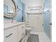 Bright bathroom featuring a white vanity, toilet, and a shower-tub combo with glass doors at 497 Island Cir, Sarasota, FL 34242