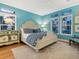 Serene bedroom featuring blue walls, a patterned bedspread, and multiple windows offering ample natural light at 497 Island Cir, Sarasota, FL 34242