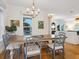Bright dining room with a large wooden table, stylish chairs, and abundant natural light from large windows at 497 Island Cir, Sarasota, FL 34242