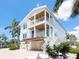 Bright, multi-story home showcasing spacious balconies, covered parking, and a charming coastal aesthetic amidst lush greenery at 497 Island Cir, Sarasota, FL 34242