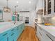 Bright kitchen with white cabinets, hardwood floors, and a blue accent island at 497 Island Cir, Sarasota, FL 34242