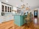 Modern kitchen featuring a teal island with a breakfast bar, white cabinetry, and pendant lighting at 497 Island Cir, Sarasota, FL 34242