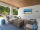 Inviting outdoor living area with comfortable seating, a TV, and a view of the lush backyard at 497 Island Cir, Sarasota, FL 34242