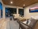 Inviting outdoor seating area featuring a wood plank ceiling, travertine tile flooring, and comfortable wicker furniture at 497 Island Cir, Sarasota, FL 34242
