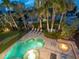 Aerial view of a private pool and hot tub area surrounded by lush landscaping and a cozy fire pit at 497 Island Cir, Sarasota, FL 34242