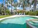 Picturesque pool area with palm trees, lounge chairs, and lush tropical landscaping at 497 Island Cir, Sarasota, FL 34242