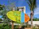 A colorful Siesta Key Village sign is surrounded by lush landscaping, welcoming visitors and residents at 497 Island Cir, Sarasota, FL 34242