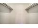 View of a simple, empty closet featuring white walls and shelves with metal racks for hanging clothes at 500 N Jefferson Ave # 5, Sarasota, FL 34237
