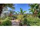 Lush backyard garden with stone path, bench, and diverse tropical plants, creating a serene outdoor retreat at 5022 46Th W St, Bradenton, FL 34210