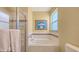 Bright bathroom featuring a built-in tub with shower and a white tile surround at 5022 46Th W St, Bradenton, FL 34210