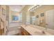 Bathroom featuring double sinks, vanity, large mirrors, and a separate tub and shower at 5022 46Th W St, Bradenton, FL 34210