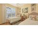 Bedroom with twin beds, window with shutters, hardwood floors, and warm yellow walls at 5022 46Th W St, Bradenton, FL 34210