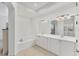 A bright bathroom with a soaking tub, double sinks, a large mirror, and tile floors at 5405 46Th W Ct, Bradenton, FL 34210