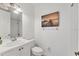 Clean bathroom with a white sink, toilet, shower, and a framed art print on the wall at 5405 46Th W Ct, Bradenton, FL 34210