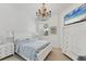 Bright bedroom featuring a bed, a television, a dresser, and a window with plantation shutters at 5405 46Th W Ct, Bradenton, FL 34210