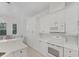 Well-lit kitchen with white cabinets and modern appliances flows to dining area at 5405 46Th W Ct, Bradenton, FL 34210