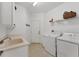 Bright laundry room with white appliances, a sink, counter space and a door to the outside at 5405 46Th W Ct, Bradenton, FL 34210