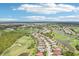 An aerial view features a golf course community with homes, lakes and lush green fairways at 5480 White Ibis Dr, North Port, FL 34287