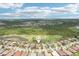 An aerial view displays houses near a golf course and wooded preserve at 5480 White Ibis Dr, North Port, FL 34287