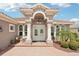 Inviting front entrance with columns, decorative windows, and a brick walkway leading to double doors at 5480 White Ibis Dr, North Port, FL 34287