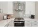 Close up of kitchen appliances with a gray backsplash and white cabinetry at 5480 White Ibis Dr, North Port, FL 34287
