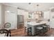 Well-lit kitchen with stainless steel appliances, gray backsplash, and a large center island at 5480 White Ibis Dr, North Port, FL 34287