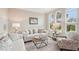Cozy living room with plenty of seating, complemented by arched windows offering a serene outdoor view at 5480 White Ibis Dr, North Port, FL 34287