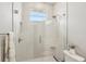 Walk-in shower with glass enclosure, tiled walls, and a window for natural light at 5480 White Ibis Dr, North Port, FL 34287