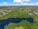 Expansive aerial view showcasing a scenic lake surrounded by trees, residential areas, and golf course at 5623 Palm Aire Dr, Sarasota, FL 34243