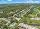 Aerial view of a residential area, showcasing the home's proximity to a golf course, pool, and nearby lake at 5623 Palm Aire Dr, Sarasota, FL 34243