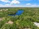 Breathtaking aerial view of a tranquil lake surrounded by lush green trees, offering a serene and natural setting at 5623 Palm Aire Dr, Sarasota, FL 34243