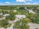 An aerial view showcases this property nestled among trees and overlooking the golf course at 5623 Palm Aire Dr, Sarasota, FL 34243