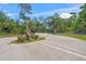 Inviting entrance with stone pillars, black metal gates, and lush greenery, creating an exclusive community at 5623 Palm Aire Dr, Sarasota, FL 34243