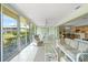 Sun-filled Florida room with an adjoining dining area and large windows offering backyard views at 5623 Palm Aire Dr, Sarasota, FL 34243