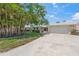 Charming single-story home with a well-manicured lawn, palm trees, and a spacious driveway at 5623 Palm Aire Dr, Sarasota, FL 34243