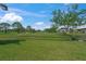 Scenic view of the golf course highlighting the lush green landscape and mature trees under a blue sky at 5623 Palm Aire Dr, Sarasota, FL 34243