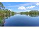 Scenic lake view with lush trees and a clear blue sky, perfect for relaxation and nature lovers at 5623 Palm Aire Dr, Sarasota, FL 34243