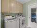 Bright laundry room features modern washer and dryer with lots of cabinet space above at 5623 Palm Aire Dr, Sarasota, FL 34243
