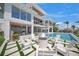 Stunning backyard featuring a modern pool, comfortable seating, and a cozy fire pit area for relaxation at 619 Key Royale Dr, Holmes Beach, FL 34217